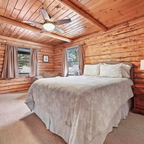 Bedroom #1 (main floor):  features a queen-size bed, chair, nightstand, closet, ceiling fan, and private bathroom entrance.