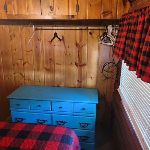 Bedroom #1:  features a queen-size bed, nightstand, lamp, mirror, dresser, and clothes rack.