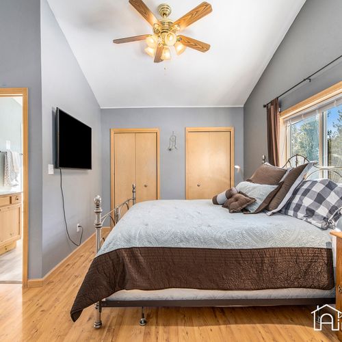 The loft master bedroom features a comfortable king bed and boasts vaulted ceilings trimmed with wood beams, pictureque alpine views, and a 3-piece ensuite bath.