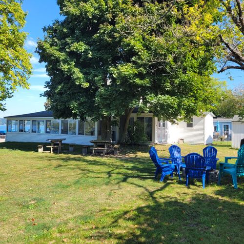 EXTERIOR:  Another view of the cottage showing the bonfire ring  along with the cottage, picnic tables, and gas grill in the background.