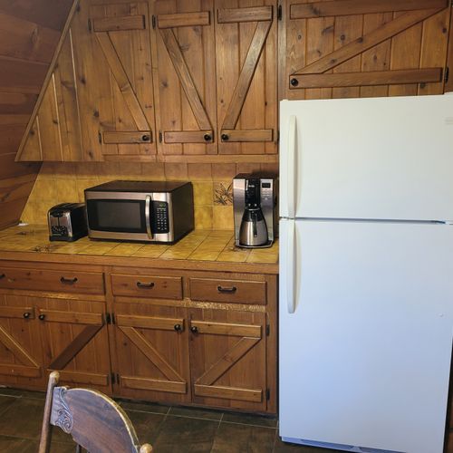 Kitchen:  features an electric range, sink, counter space, cabinets, refrigerator, microwave, and coffee maker. (no dishwasher though. )