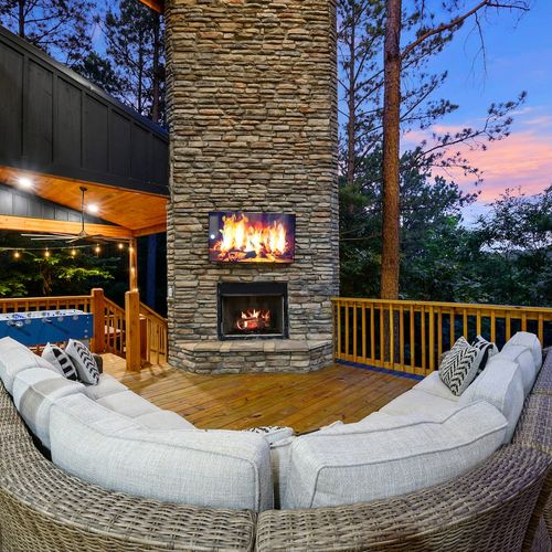 Outdoor patio with an oversized sofa around the fireplace!