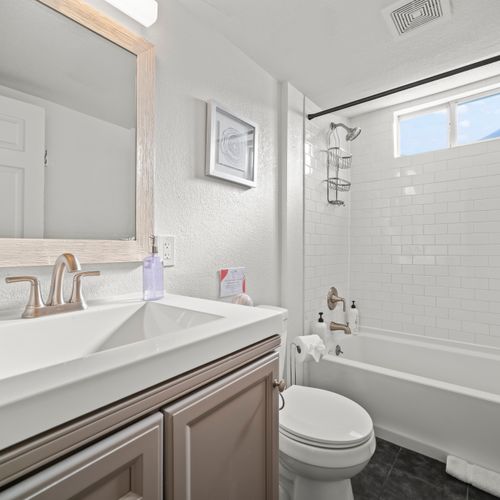 Experience spa-like amenities in the fully remodeled bathroom featuring a large tub/shower combo, extended modern vanity and ambient lighting.