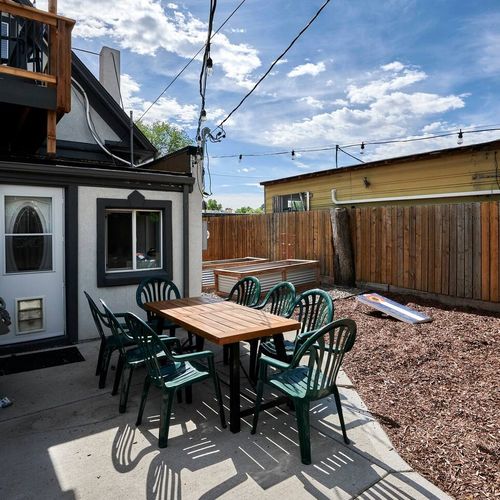 - dine outdoors with friends and family in this relaxed patio space for eight
- cornhole and gravel yard offer laid back entertainment under the sun
- string lights and fence backdrop make this area ideal for evenings too