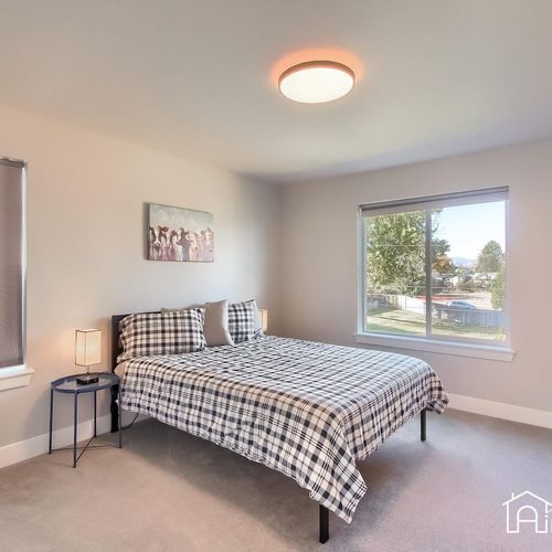 The third bedroom offers a picturesque view of the neighborhood and rocky mountain peaks and convenient access to the shared bathroom.
