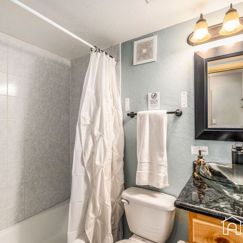 A spacious lower level bathroom stocked with travel toiletries and plush towels for your convenience.