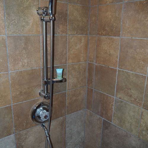 Bathroom:  features a shower and a toilet. (note that there is no vanity, sink, or mirror in the bathroom. )