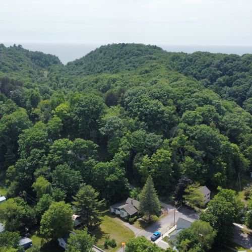 Overall:  the famous dunes of elberta and lake michigan in the background with the home at the bottom center of the photo.