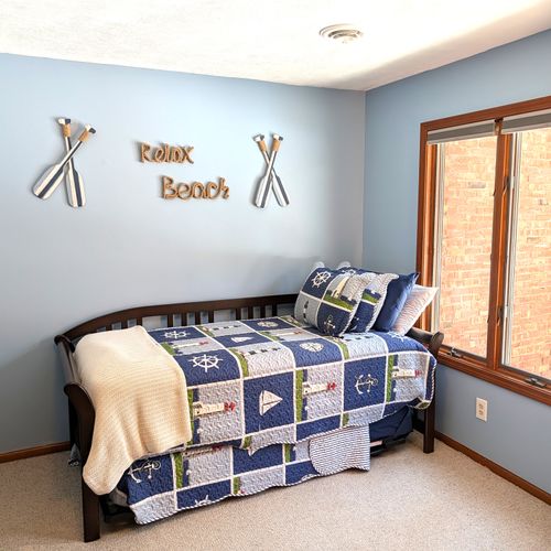 BEDROOM #1 (FIRST FLOOR):  There is a small bedroom with a trundle bed on the first floor.  Includes a closet, dresser, and mirror as well.