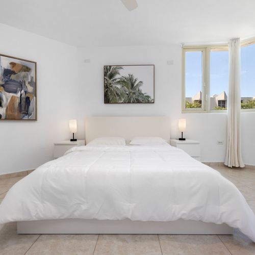 Serene master bedroom featuring a king-size bed and artistic decor.