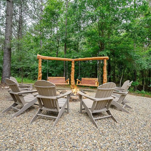 Fire pit surrounded by Adirondack chairs.