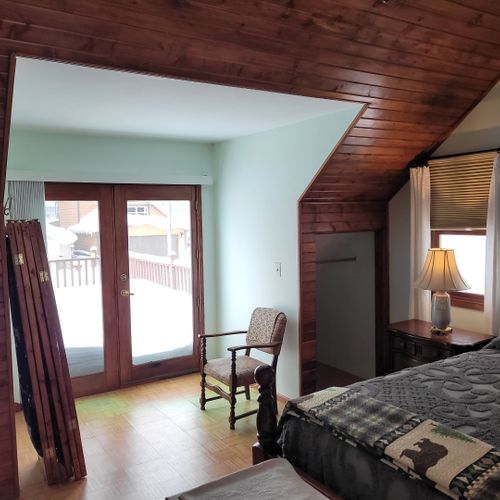Bedroom #2 (second floor):  very large bedroom features a queen-size bed, walk-out deck, chair, 2 nightstands, 2 lamps, 2 dressers, ceiling fan, television, and private en suite full bathroom