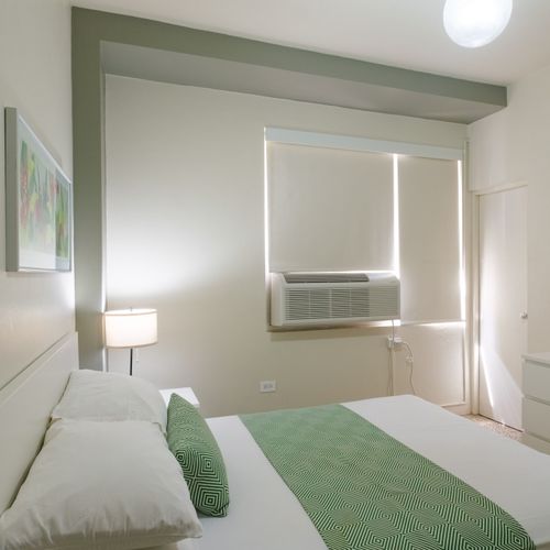 Experience ultimate comfort in our well-lit bedroom, complete with modern furnishings, blackout blinds for undisturbed sleep, and a refreshing air conditioning unit to keep you cool.