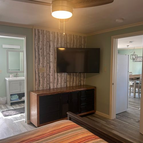 Bedroom:  cute bedroom with queen-size bed, ceiling fan, private streaming television, dresser, closet, nightstand, and lamp.