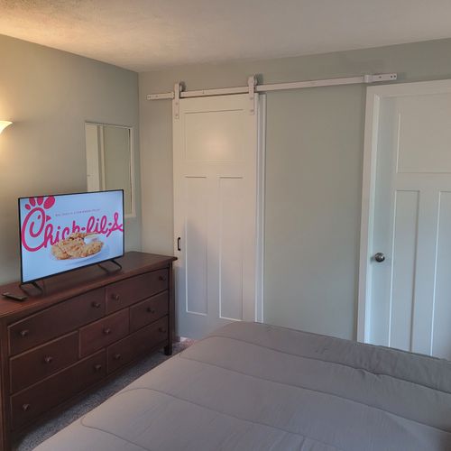 BEDROOM #1:   Master bedroom with a queen-size bed, walk-in closet, private en suite full bathroom, and streaming television.