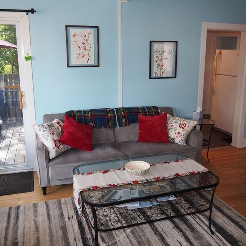 Living room:  comfy and cozy living room with sofa, comfy chair, futon, 2 coffee tables, and a large live streaming television that uses the cottage's high-speed cable wi-fi.