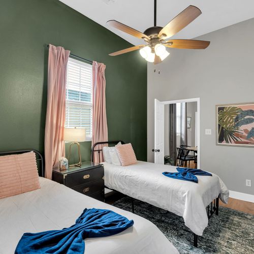 Bright, airy bedroom w/ a bed & soft peach tones — easy comfort for extra guests.