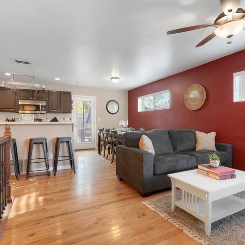 - open layout connects kitchen, dining, and living areas for seamless flow
- bold red accent wall adds warmth to this modern and inviting space
- from coffee at the bar to group dinners, this area is built for connection