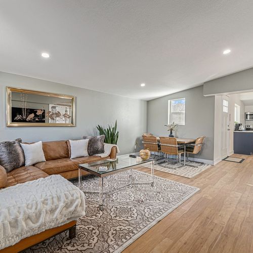 - spacious open concept layout features a cozy sectional, dining table for four, & layered rugs
- soft gray walls and light wood floors create a calm and cohesive backdrop
- plenty of natural light makes this space perfect for relaxing or gathering