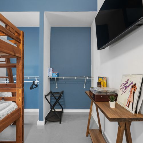 Experience comfort in our well-lit room featuring a sturdy wooden bunk bed. Ideal for friends or family traveling together.