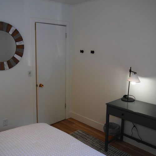 Bedroom #1:  features a king-size bed, nightstands, lamps, ceiling fan, chair, desk, and a closet.