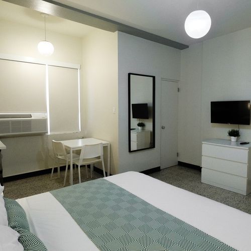 This functional yet comfortable space offers a cozy bed, ample storage, and a small table, perfect for catching up on work or enjoying a quiet meal.