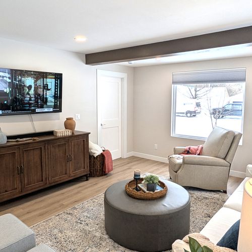 LIVING ROOM:  The home has a gorgeous newly-decorated living room with a sofa, comfy chairs, ottoman, and large screen television