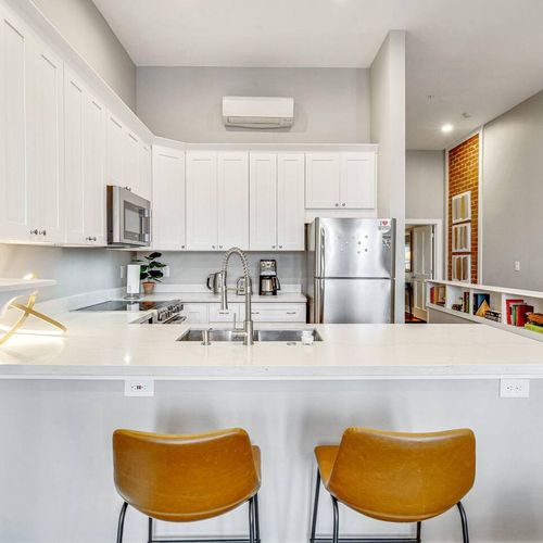 Sleek white kitchen & bar area w/ plenty of counter space for hosting.