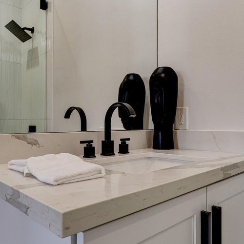 Master bath vanity w/ custom cabinetry & quartz counters in crisp black & white.