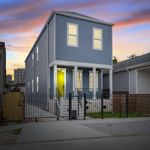 Striking blue exterior glowing at dusk — a home that turns heads.