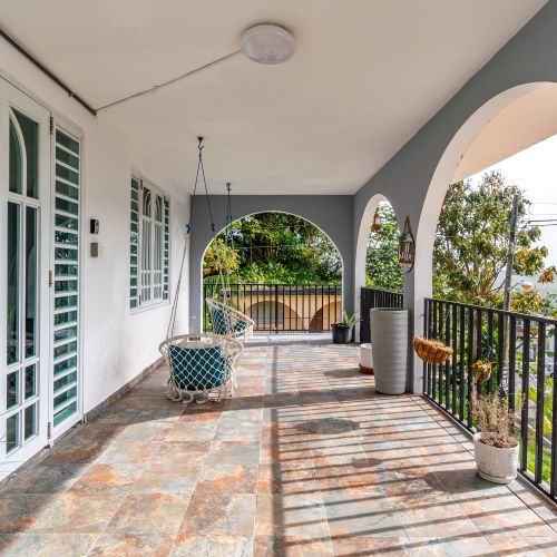 Spacious outdoor patio with unique, hanging swing chairs.