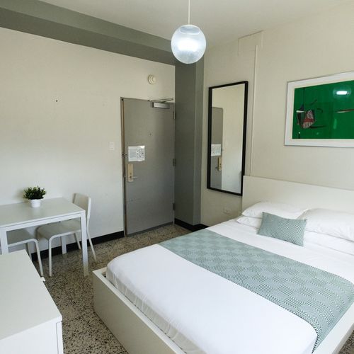 Relax and recharge in this charming bedroom offering a comfortable bed and a dedicated desk area, perfect for catching up on emails or planning your next adventure.