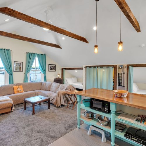 Airy living & dining area w/ exposed beams & warm, natural light.