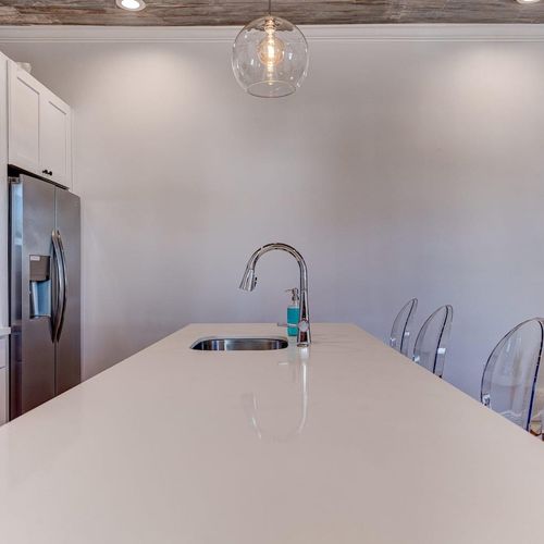 Crisp white kitchen countertops w/ plenty of prep space to cook like at home.