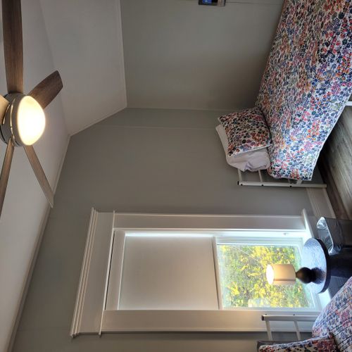 Bedroom #4 (second floor):  features a queen-size bed, twin bed, window a/c unit, ceiling fan, nightstand, lamp, dresser, and a closet.