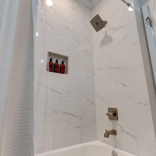 Bright bathroom w/ sink & a relaxing tub to soak away the day.