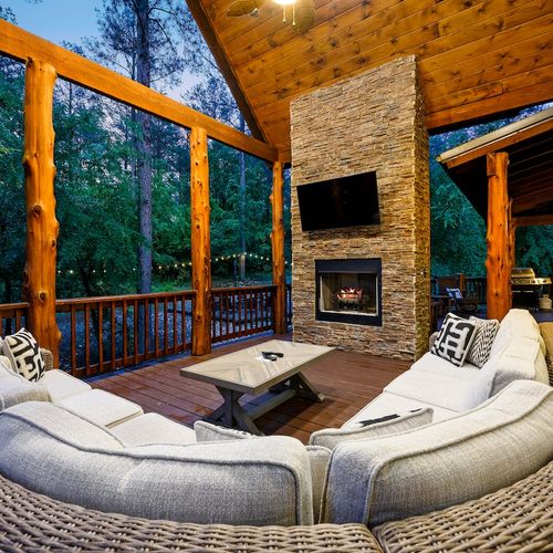 The covered patio has an oversized sectional around the fireplace.
