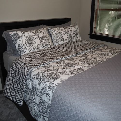 Bedroom #2 (main floor):  features a queen-size bed, ceiling fan, dresser, and closet.