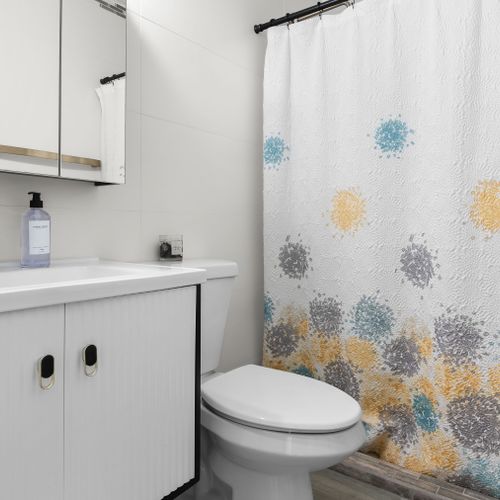 Sleek and modern bathroom with contemporary fixtures and spacious shower. Designed for your comfort.