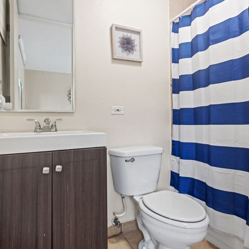 A clean and functional bathroom with a stylish striped shower curtain.