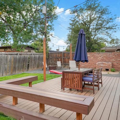- enjoy morning coffee or sunset drinks on this private backyard deck with bench seating
- overhead string lights and a cozy dining setup invite you to linger outside
- great for relaxing, reading, or gathering for a meal under the sky