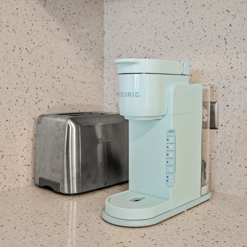 Start your morning fresh with a cup of coffee from our chic mint Keurig and a crispy toast from the sleek toaster.