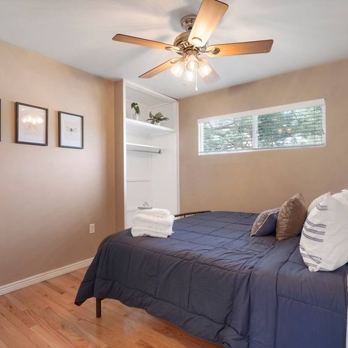 - bright bedroom with cozy navy bedding, soft lighting, and built in closet space
- three minimalist art pieces add a stylish accent to the clean, warm walls
- great choice for restful sleep or afternoon naps under soft window light