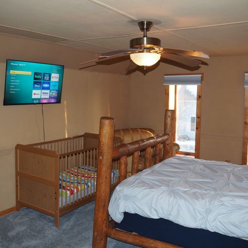 Bedroom #4 (second floor):  features a queen-size bed, private television, sofa bed, comfy chair, ceiling fan, baby crib, and a dresser.