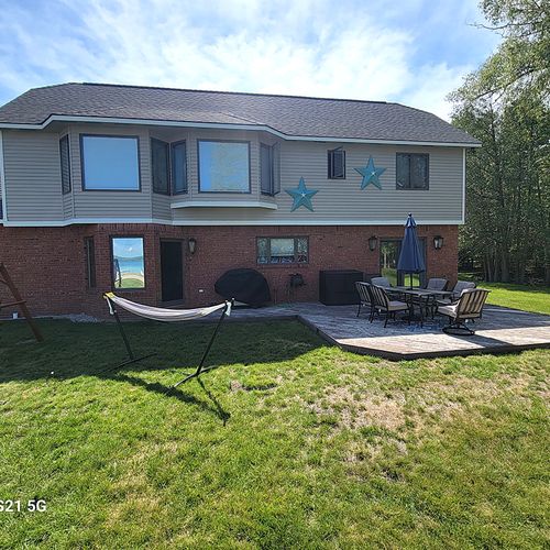 OVERVIEW:  The back of the home in the winter, showing the hammock, swing, and outdoor patio with outdoor dining furniture.
