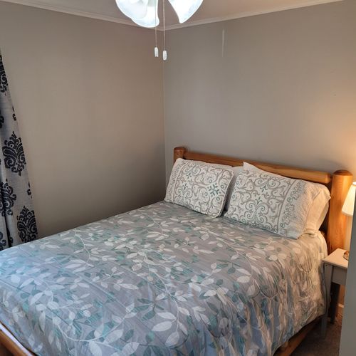 Bedroom #1:  features a queen-size bed, ceiling fan, nightstand, lamp, closet, and dresser.