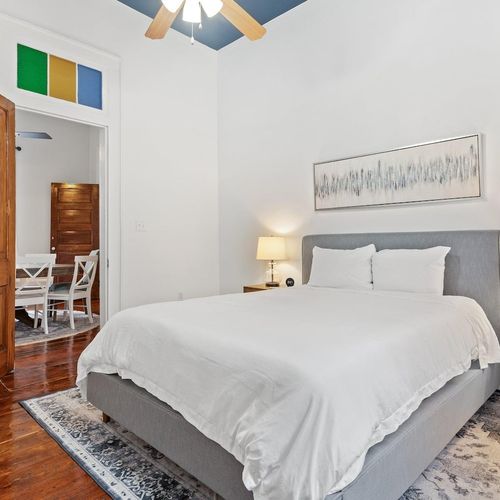 Serene bedroom w/ white bedding & soft light — a peaceful space to recharge.