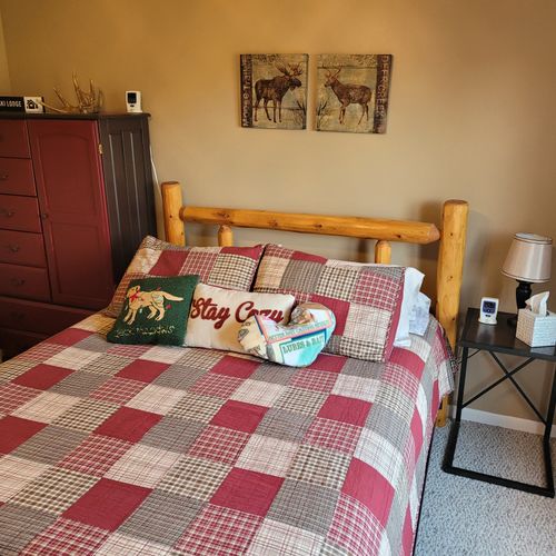 BEDROOM #1 (FIRST FLOOR):  Features a beautiful queen-size bed, ceiling fan, dresser, nightstand, lamp, closet, and makeup table with chair and mirror.