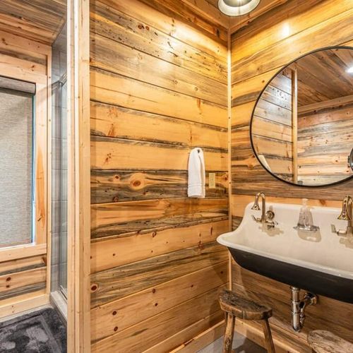 The private bathroom featuring a trough sink and walk-in shower.