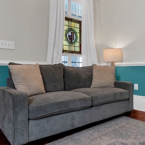 Plush grey sofa in a calm, teal-accented room — unwind & settle in for the night.